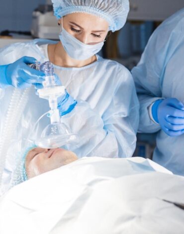 Genel anestezi altında uyutularak diş tedavisi yapılan bir hastayı takip eden anestezi ekibi ve diş hekimi.