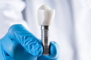 Çene kemiğine yerleştirilen dental implant ve üzerine yapılan protez ile çiğneme fonksiyonunu gösteren dental görsel.